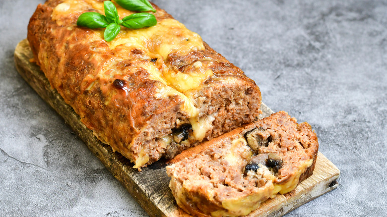 Cheesy meatloaf on wooden board