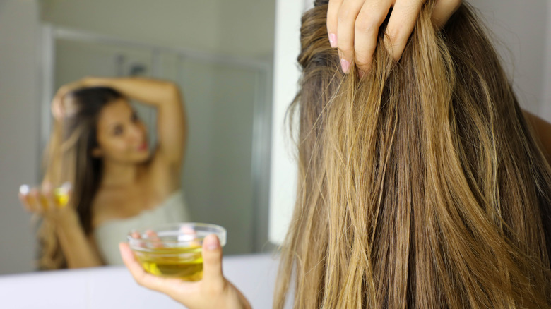 woman putting olive oil hair