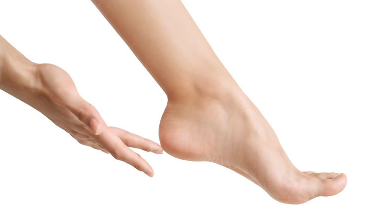 hand touching cracked heel