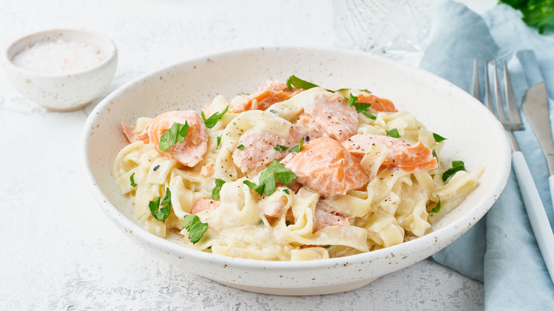 Salmon on white sauce pasta with garnish