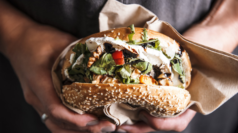 Woman holding bagel sandwich