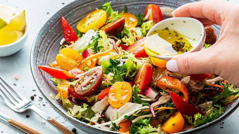 Pouring dressing over salad