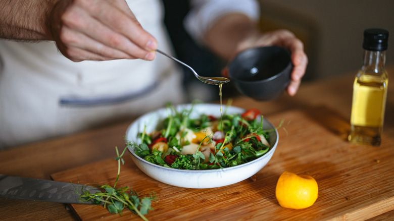 Chef drizzling salad dressing