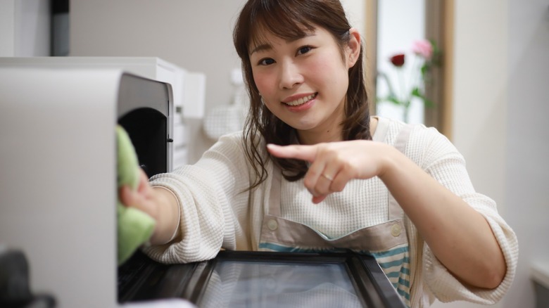 Woman cleaning toaster oven