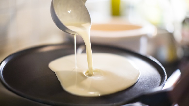 Ladling pancake batter into skillet