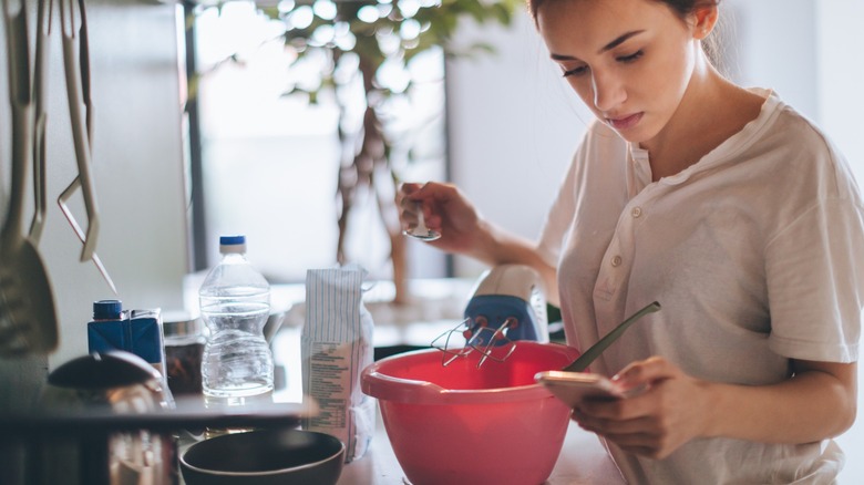 Woman baking using recipe