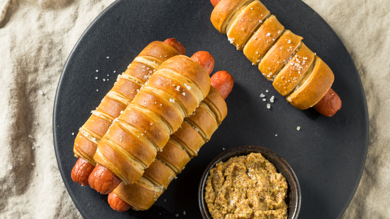 Four pretzel roll hot dogs