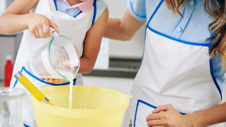 Pouring milk into yellow bowl