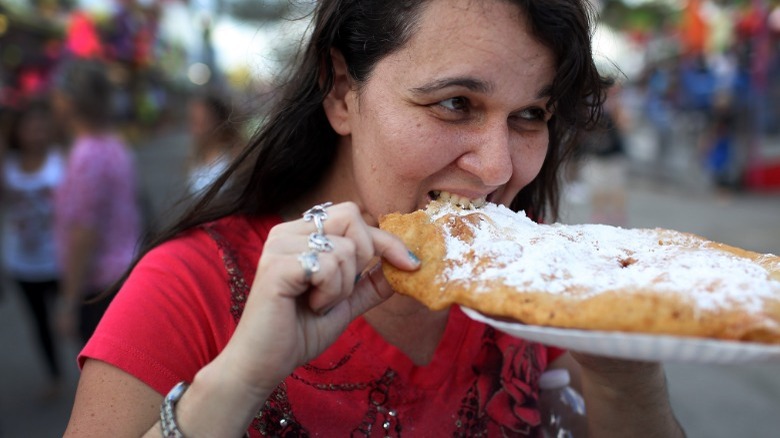 Woman biting into funnel cake