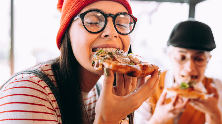 woman eating pizza slice