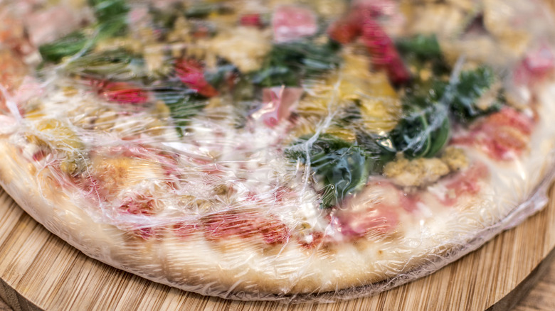 frozen pizza in plastic wrap