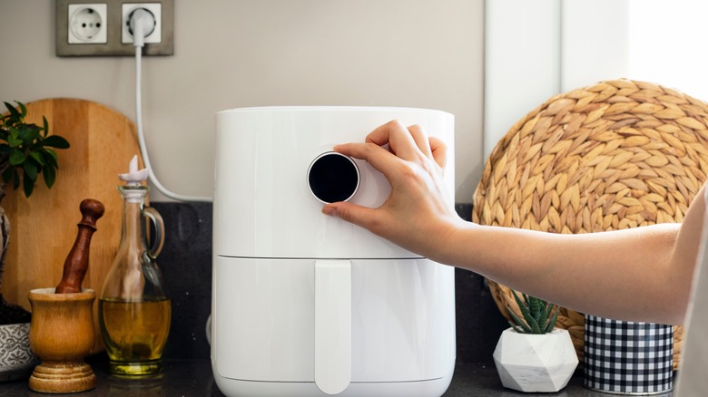 Hand adjusting air fryer