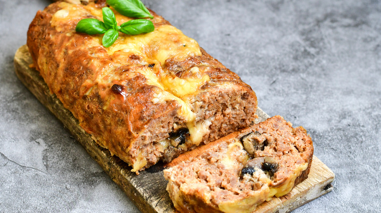 Cheesy meatloaf on cutting board