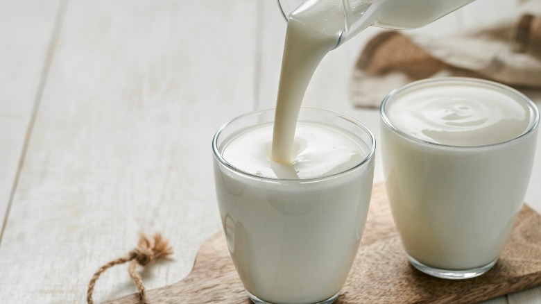 Two glasses of buttermilk, one being poured