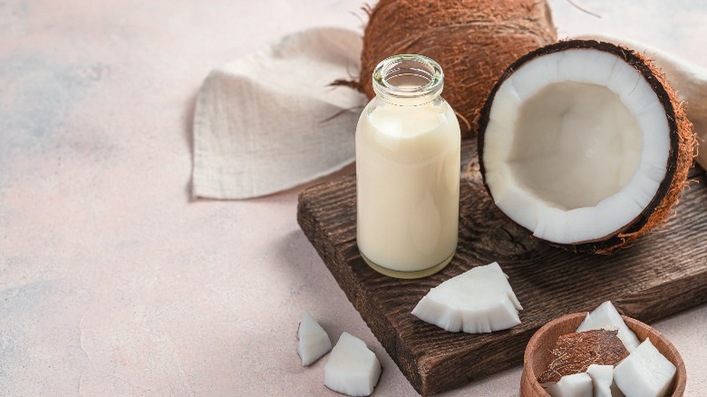 Bottle of coconut milk with cut coconut