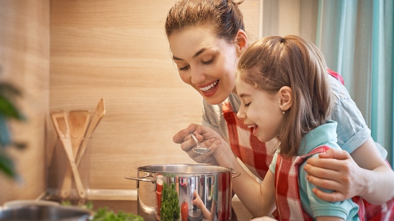 Mom and daughter cooking soup