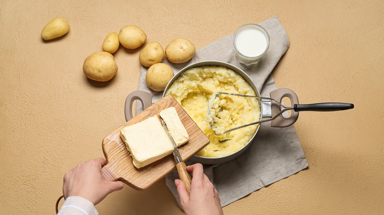 adding butter to mashed potatoes