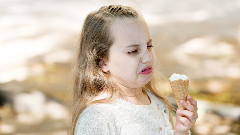 Child tasting ice cream cone