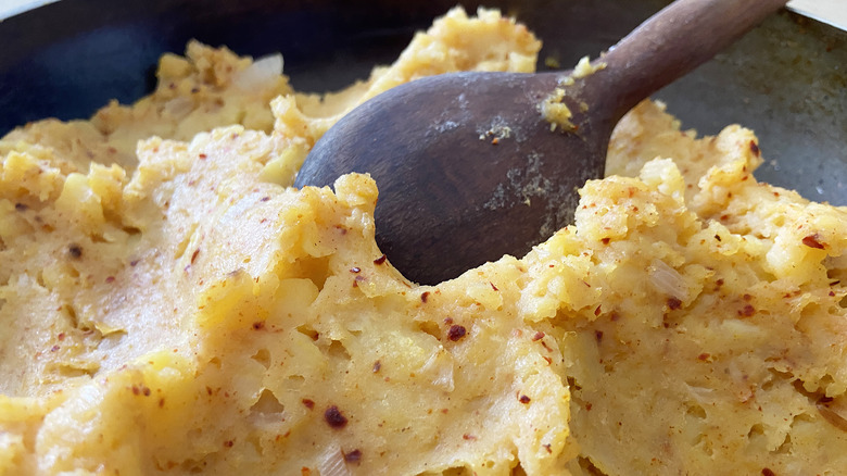 spoon stirring spiced mashed potatoes