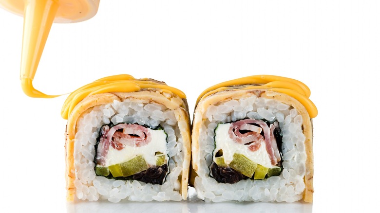 Squeezing mayo over sushi roll