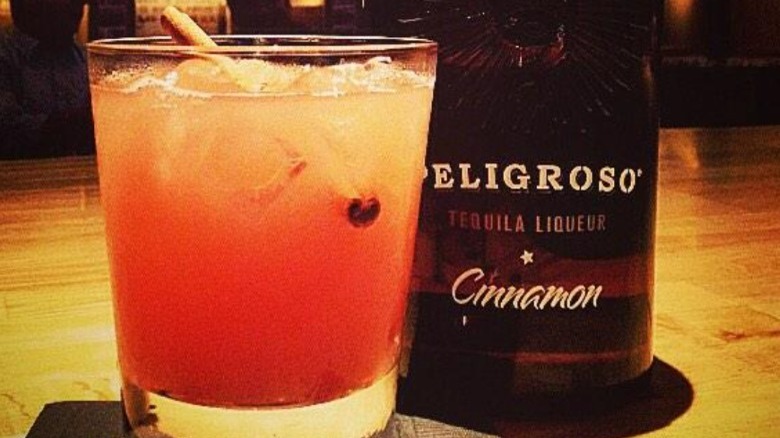 A bottle and glass of Peigroso Cinnamon Tequila