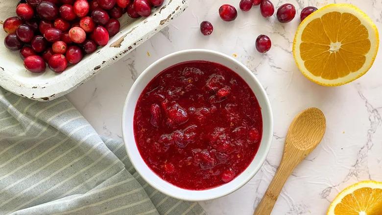 Cranberry sauce in bowl with halved orange