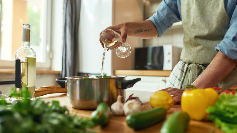 Person cooking with white wine