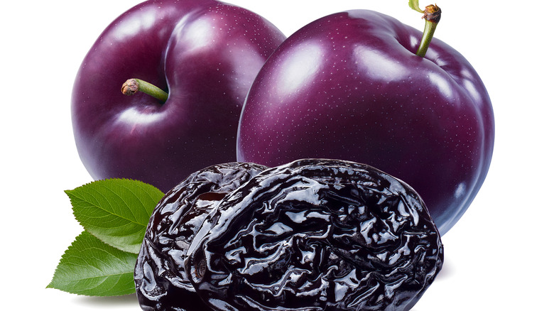 Plums and prunes on white background