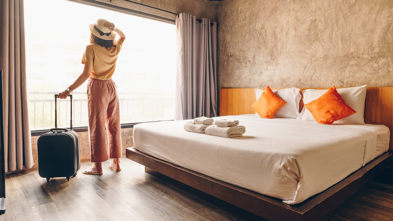 Woman in hotel room looking at view