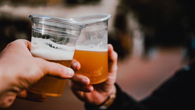 people toasting with beer in plastic cups