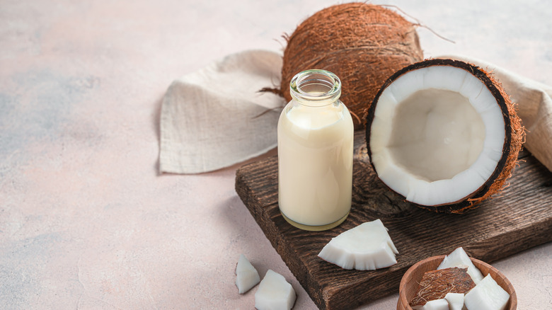 Jarred milk next to coconuts