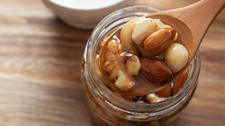 Spoon with nuts in honey