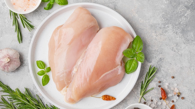 raw chicken breasts on plate