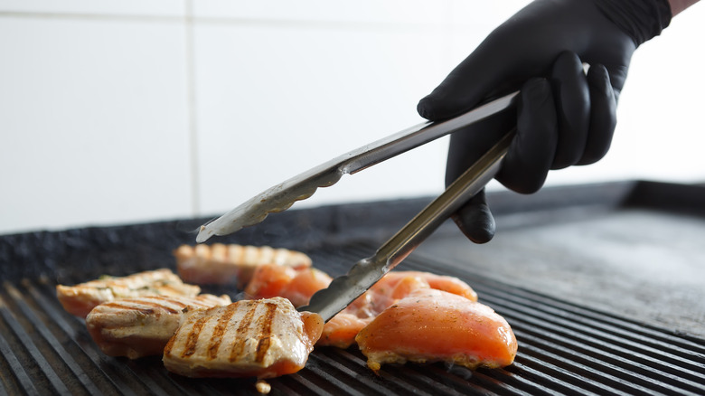 flipping chicken with tongs