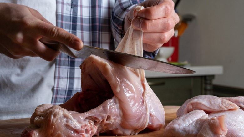 cutting skin off of raw chicken