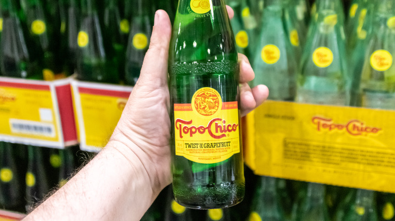 man holding topo chico bottle