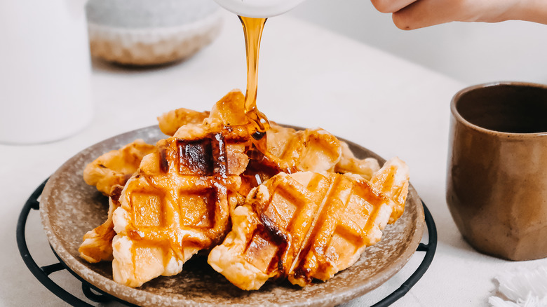 pouring syrup on waffles