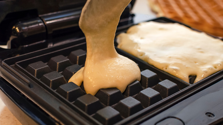 pouring batter on waffle maker