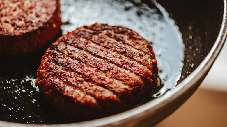 Burgers frying in pan