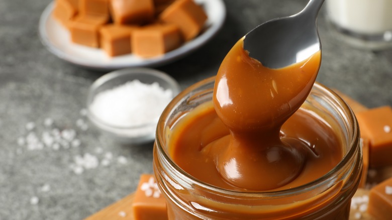 spoon in jar of caramel sauce