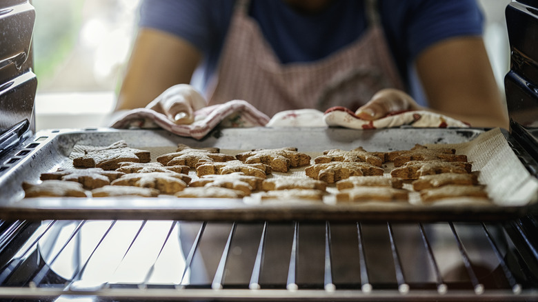 pulling cookie tray out of oven