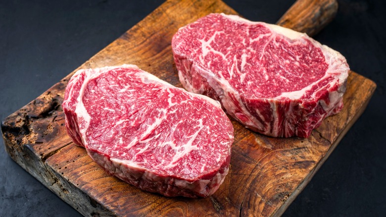 raw steak on wooden board