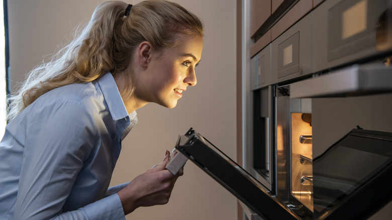 woman opening oven door