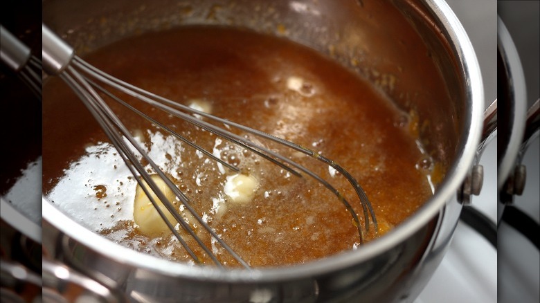 whisking sauce in stainless pot