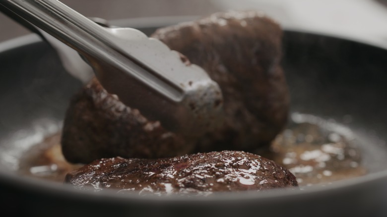 Flipping steaks with tongs