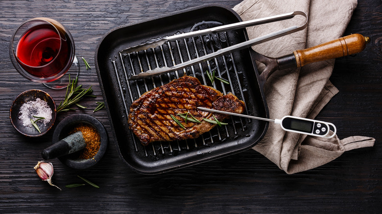 Thermometer in steak on skillet