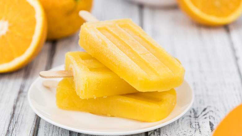 stacked orange popsicles on plate