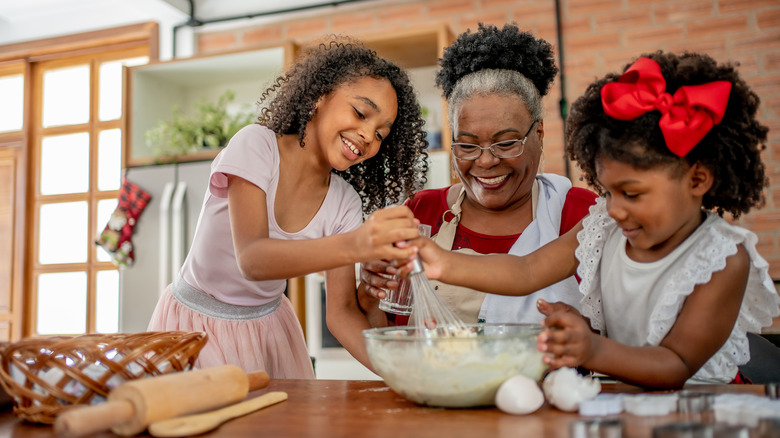 woman and girls making cake