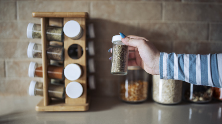 grabbing seasoning bottle from spice rack