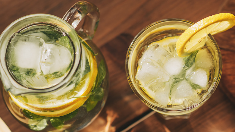 Pitcher of lemonade and glass of lemonade with ice